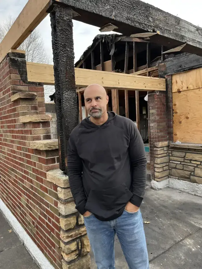 Henry Owens at a fire-damaged St. Louis house he bought and rebuilt